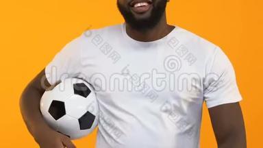 年轻的黑人男子投掷足球，竖起大拇指，进行体育训练